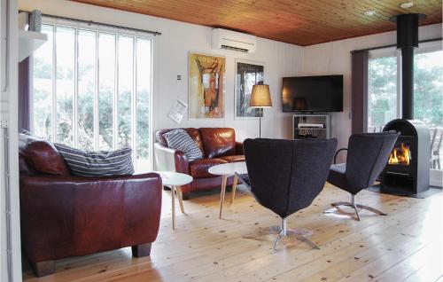 a living room with leather furniture and a fireplace at Holiday Home Ristinge Sommerland Humble I in Humble