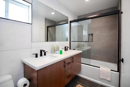 y baño blanco con lavabo y ducha. en Los Angeles 3BR Villa Suites with Free Parking, en Los Ángeles