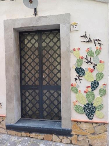 a black door on the side of a building with cactuses at Etnalcantara1 in Castiglione di Sicilia