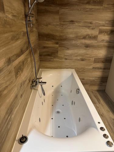 a white bath tub with a shower in a bathroom at Utopia Hotel - Art & Nature Hotel in Mons