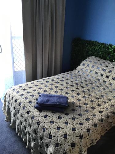 Una cama con una almohada azul encima. en Strawberry fields, en Devonport