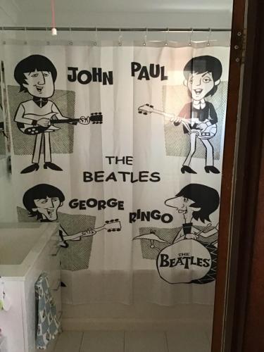 a shower curtain with the beatles on it in a bathroom at Strawberry fields in Devonport