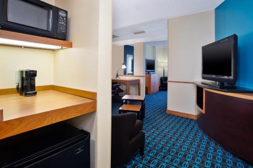 a hotel room with a television and a living room at Fairfield Inn & Suites by Marriott Lexington North in Lexington