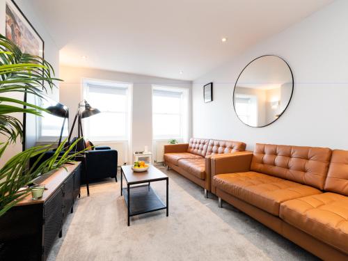 sala de estar con sofás de cuero marrón y espejo en Waimea Apartments - Sea Views South Bay Scarborough Free Parking en Scarborough