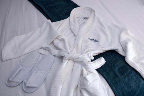 a white robe with a pair of flip flops at The Spa at Norwich Inn in Norwich