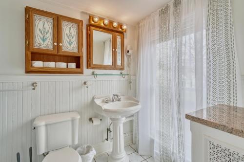 a white bathroom with a sink and a toilet at 1 Bedroom Treetop Apartment on Capitol Hill! in Washington, D.C.