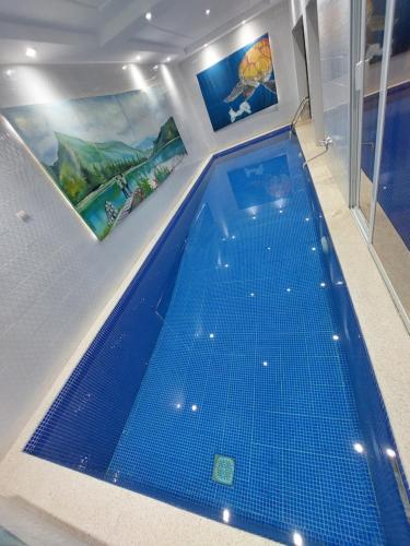 a large blue swimming pool in a room at Piscine privative et prestations haut de gamme in Dakar