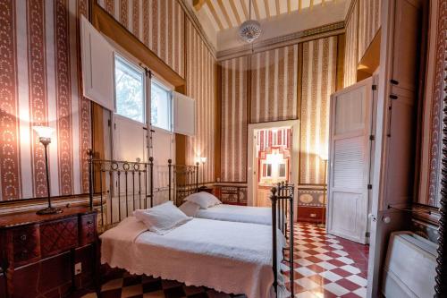 a bedroom with two beds and a window at Hacienda San Antonio Millet in Tixkokob