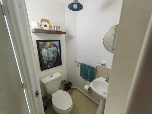 a white bathroom with a toilet and a sink at Casa Meraki in Querétaro