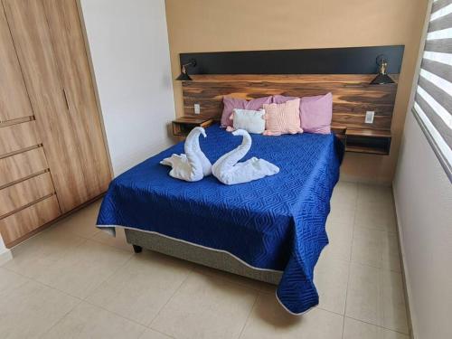 dos cisnes acostados en una cama en un dormitorio en Casa Meraki en Querétaro