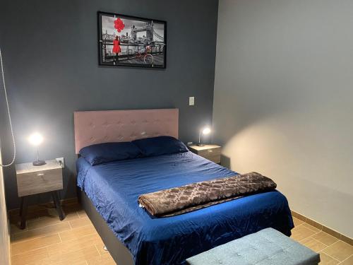 1 dormitorio con 1 cama con edredón azul en Sayula luxury apartments, en Sayula