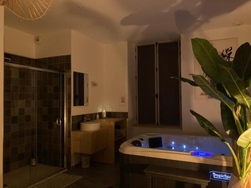 uma casa de banho com uma banheira grande e um chuveiro em Profitez d'une douce nuit avec jacuzzi em Fougères