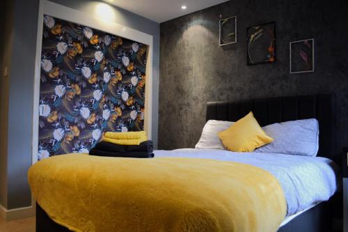 a bedroom with a large bed with a yellow blanket at Heart of Leeds - 2 Bedroom Flat in Leeds