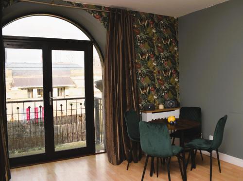 a dining room with a table and chairs and a window at Heart of Leeds - 2 Bedroom Flat in Leeds