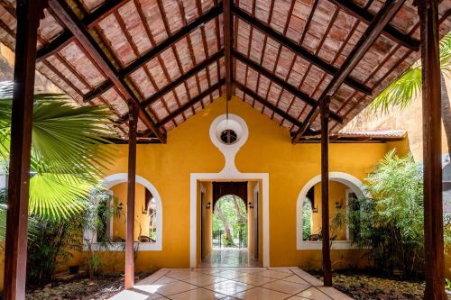 an entry to a house with a wooden ceiling at Hacienda San Antonio Millet in Tixkokob