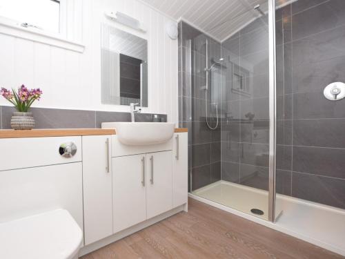 een witte badkamer met een wastafel en een douche bij 1 Bed in Langbank 73846 in Langbank