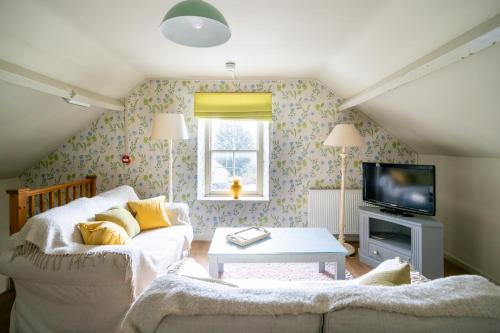 a living room with a couch and a tv at The George in Bradford on Avon