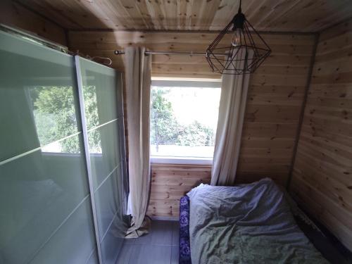 a bedroom in a log cabin with a window at Domki nad morzem i jeziorem in Jezierzany