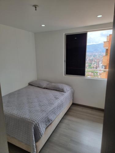 1 dormitorio con cama y ventana grande en Cómodo apartamento, en Medellín