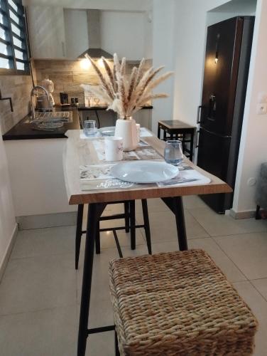 a table with a plate on it in a kitchen at Spacieux T2, Bord De Mer Sable Volcanique in Saint-Paul