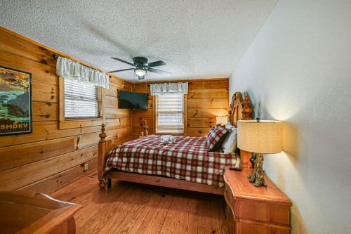 Bryson City Cabin with Private Hot Tub and Pool Table! في بريسون سيتي: غرفة نوم بسرير ومروحة سقف
