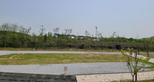 a park with a field of grass and a road at Starium Seocheon in Seocheon