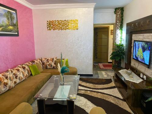 a living room with a couch and a tv at Appartement meublé Tanger in Tangier
