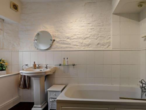 a white bathroom with a sink and a tub at 3 Bed in Alston 89994 in Slaggyford
