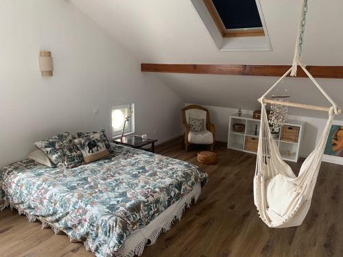 La Ferme Pouchuc في Bénesse-Maremne: غرفة نوم مع سرير يتأرجح وأرجوحة