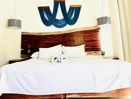 a bedroom with a large white bed with blue accents at Hotel San Vicente in Playa del Carmen
