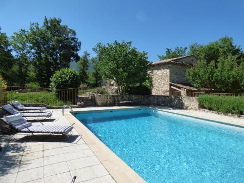 a swimming pool with two lounge chairs and a house at Hôtel Lou Caleù restaurant le Rocher des Abeilles in Saint-Martin-de-Castillon