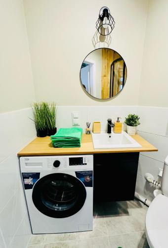 a bathroom with a washing machine and a sink at Olivia Apartments - Słoneczny apartament w centrum Warszawy, Plac Unii Lubelskiej, Łazienki Królewskie, Pole Mokotowskie - 24h check-in in Warsaw