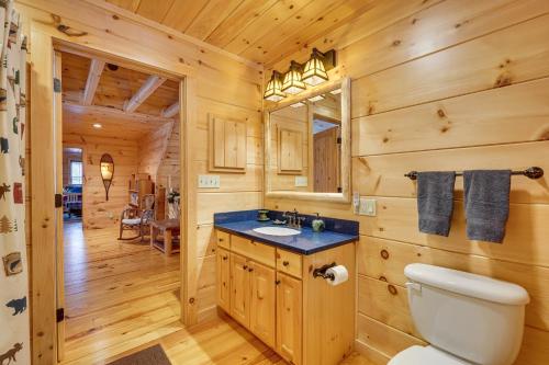 a bathroom with a toilet and a sink in a log cabin at Waterfront Old Forge Cabin with Deck and Indoor Pool in Old Forge