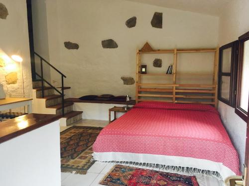 Schlafzimmer mit einem Bett mit einer roten Tagesdecke in der Unterkunft Il Borghetto sul Golfo in Magazzini