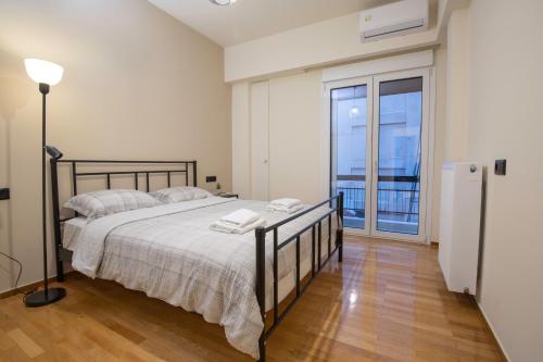 une chambre avec un grand lit et un balcon dans l'établissement Urban Spacious Apartment Near Kallimarmaron, à Athènes