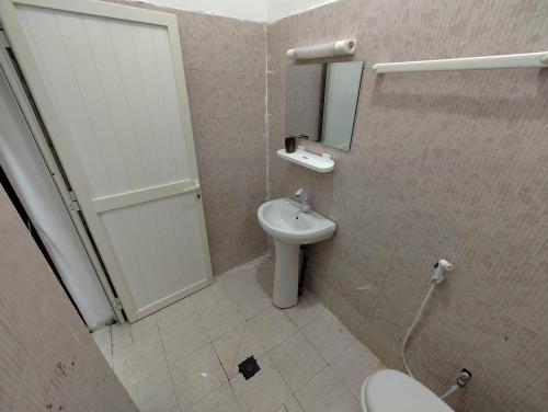 a bathroom with a toilet and a sink and a mirror at Miguil House in Djibouti