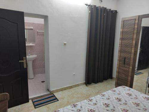 a bedroom with a bed and a bathroom at Miguil House in Djibouti