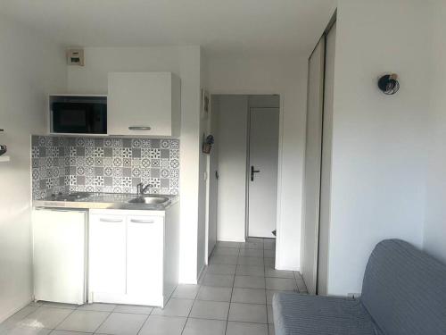 une cuisine avec un évier et un plan de travail dans l'établissement Studio - 4 pers. 10min Disney, à Bussy-Saint-Georges