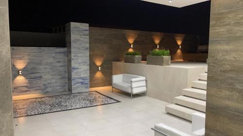 a lobby with a chair and stairs in a building at Yovanna Elegante Apartamento 1 dormitorio in Santa Cruz de la Sierra