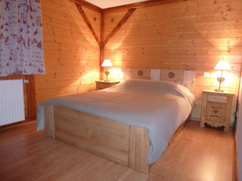 a bedroom with a bed in a log cabin at Les Bouquetins in Stosswihr