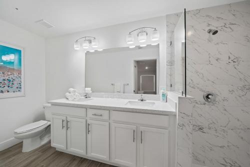 a white bathroom with a sink and a shower at New! Few Minutes To Downtown, 10 To The Beach! in West Palm Beach