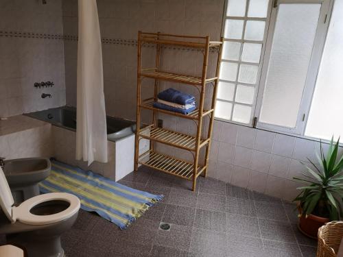 ein Badezimmer mit einem WC und einem Regal mit Handtüchern in der Unterkunft Departamento espacioso in La Paz