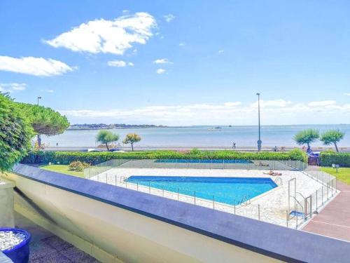 une piscine avec l'océan en arrière-plan dans l'établissement ღ La Corniche • Grand Studio, Piscine & Parking, à La Rochelle