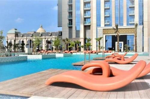 a swimming pool with orange inflatables in front of a building at Apartament Great view Dubai in Dubai