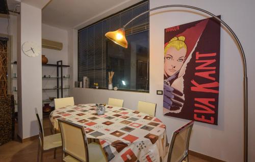 a dining room with a table and a poster on the wall at 3 Bedroom Nice Apartment In Comiso in Comiso