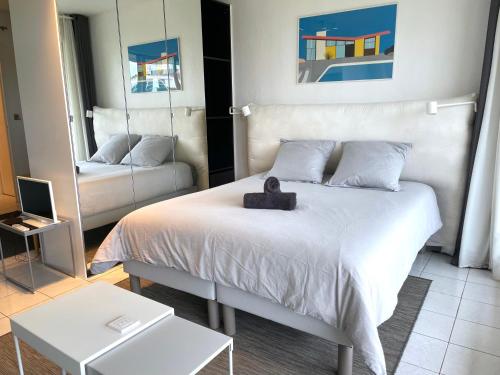 Un dormitorio con una cama con un osito de peluche. en ღ La Corniche • Grand Studio, Piscine & Parking, en La Rochelle