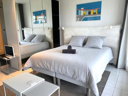 a bedroom with a bed with a teddy bear on it at ღ La Corniche • Grand Studio, Piscine & Parking in La Rochelle