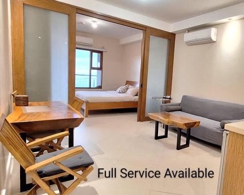 a living room with a couch and a table at Manila BayView Rental- Luxury 1,2,3,4 BR Condos with BALCONY POOL BAYVIEW - FULL SERVICE INCLUDED IN MAY in Manila