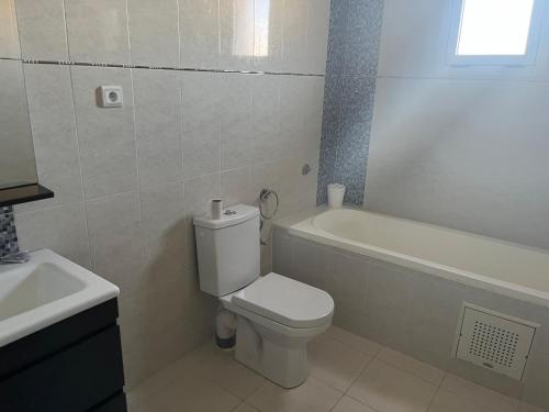 a bathroom with a toilet and a tub and a sink at Maison vue mer Al Hoceïma in Al Hoceïma