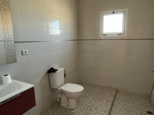 La salle de bains est pourvue de toilettes, d'un lavabo et d'une fenêtre. dans l'établissement Maison vue mer Al Hoceïma, à Al Hoceïma